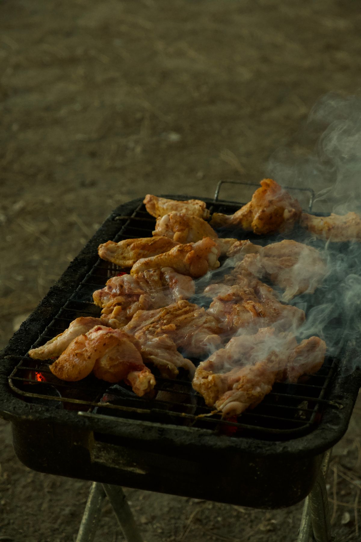 Chicken smoking away on an open drum grill